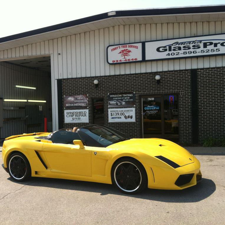 A yellow sports car parked outside of the Omaha Stereo Pro shop