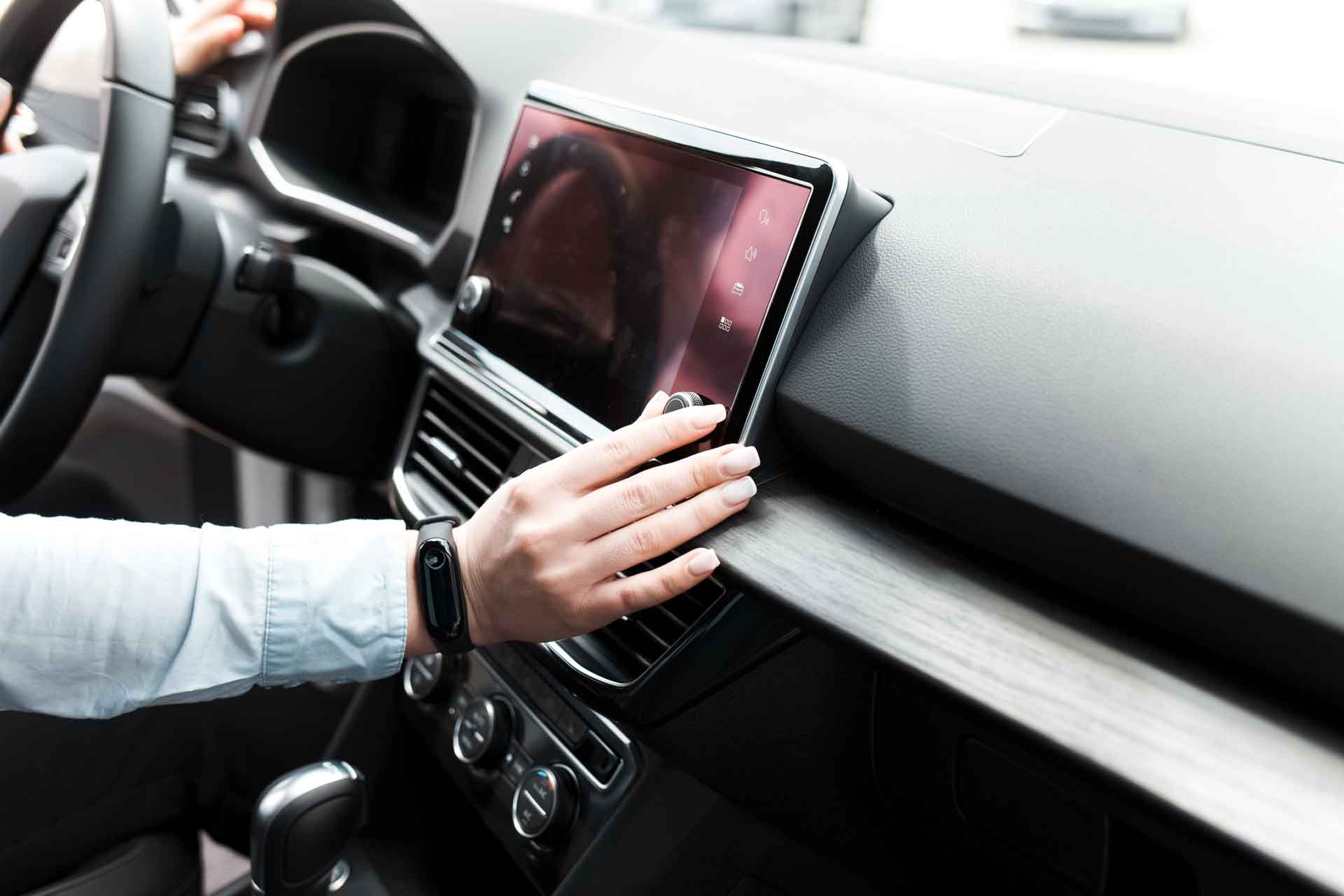 Man adjusting volume on car entertainment center